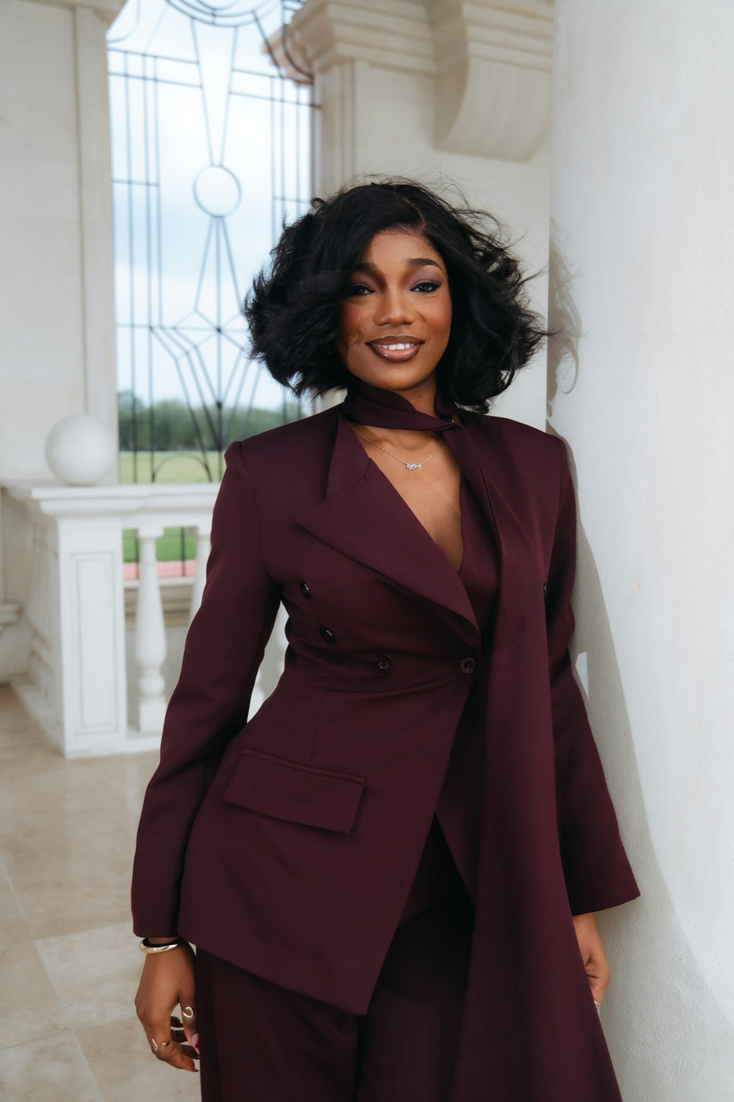A portrait in a burgundy suit